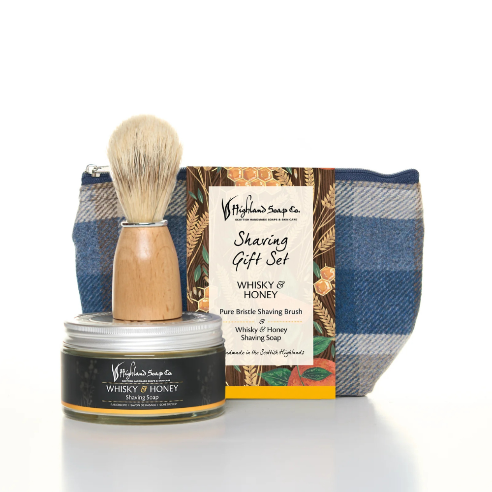 A premium Whisky & Honey Wash Bag and Shaving Set by The Highland Soap Company, including whisky and honey shaving soap, natural brush, and a stylish wash bag.