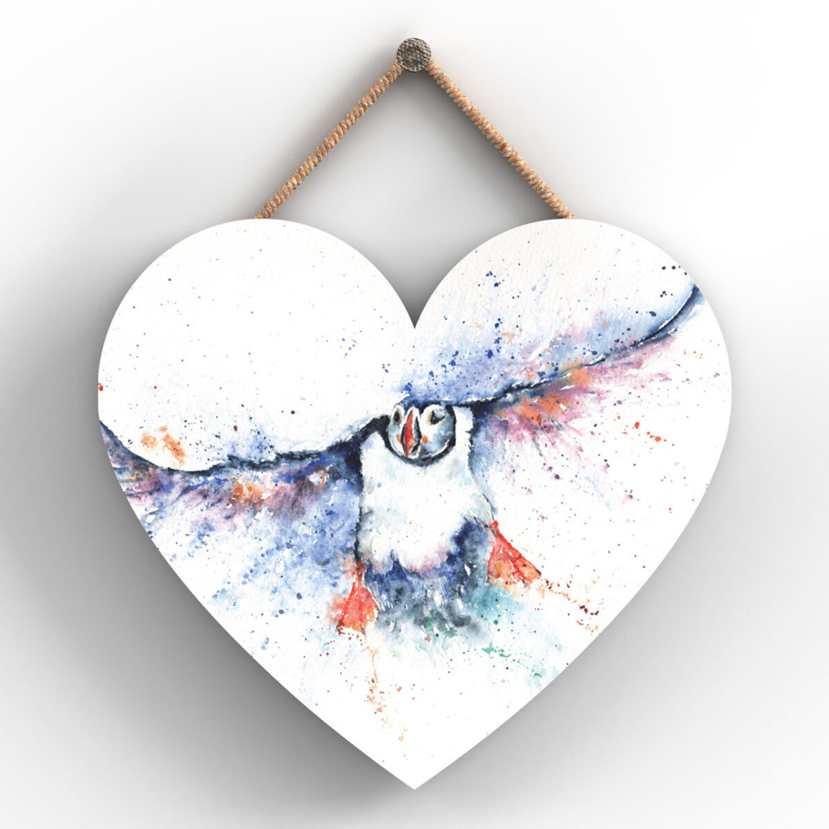 Heart-shaped wooden plaque with puffin in flight painted in expressive watercolour style