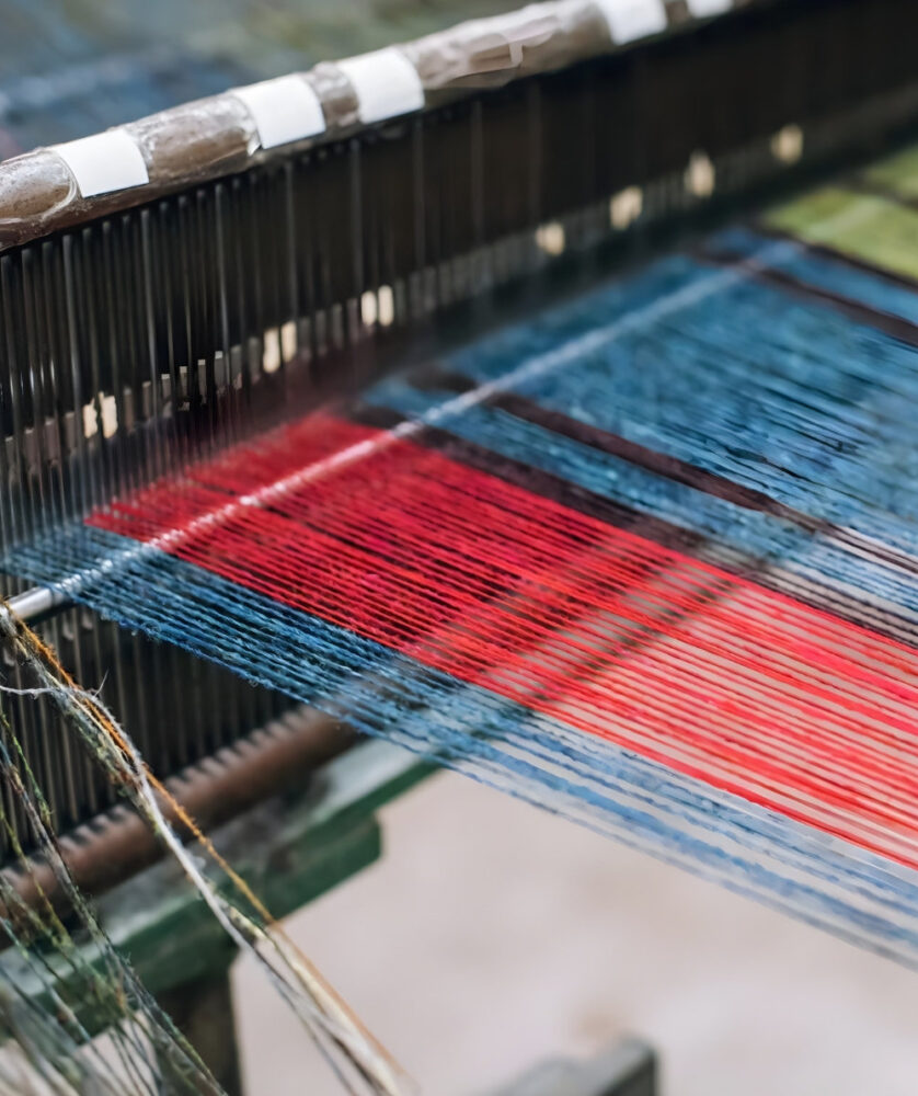 Close-up of colourful warp threads on a traditional loom handweaving Harris Tweed fabric