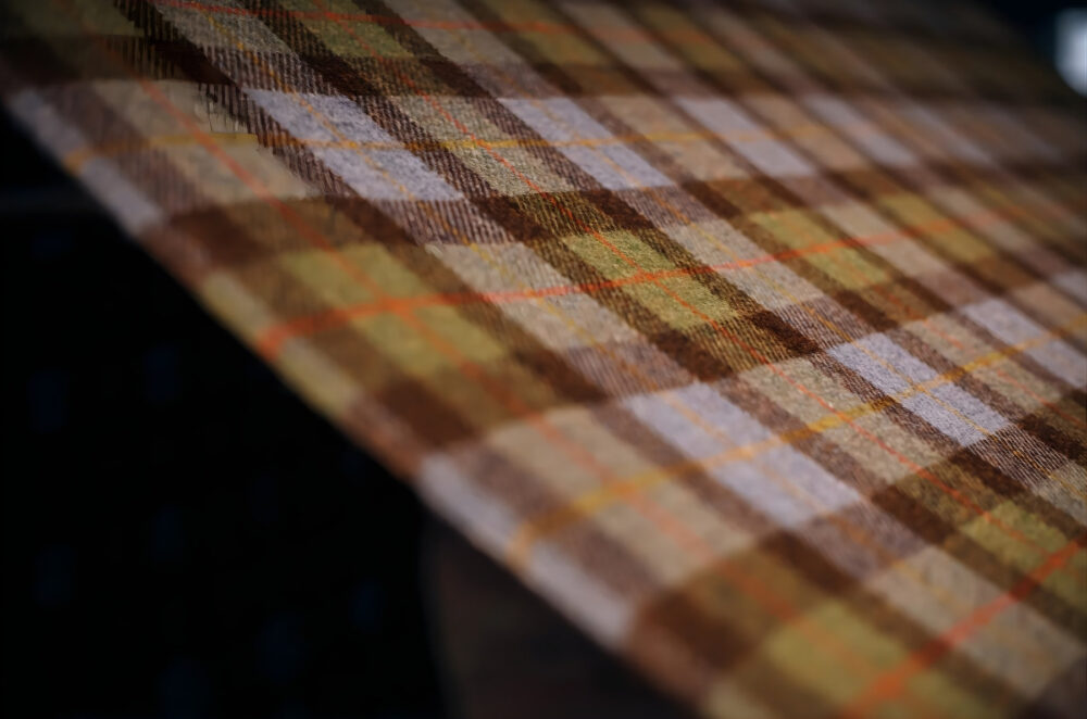 Close-up of Harris Tweed fabric in brown, yellow, orange, and white tartan pattern